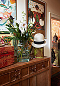 Cut flowers and sunhat with crate on wooden sideboard in Evershot home, Dorset, Kent, UK