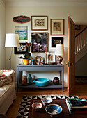 Ornaments and artwork on grey painted console in living room of London home, England, UK