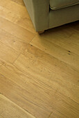 Oak parquet flooring with grey upholstered sofa