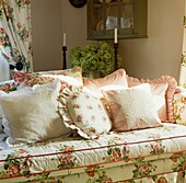 Peach and floral patterned cushions on sofa with fabric co-ordinated to curtains