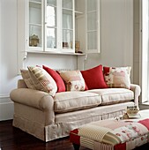Cream sofa with cushions and low ottoman stool with co-ordinated fabric