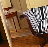 Striped chair with cushion at open door to hallway