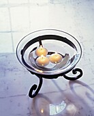 Floating candles in glass bowl on marble table top