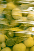 Glass jar of onions and gherkins