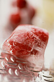 Eiswürfel mit eingefrorenen Früchten auf einem Metalltablett