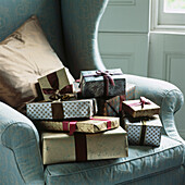 Silver and gold wrapped Christmas presents on armchair