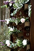 Antique chest of drawers with flowers hanging out of the drawers