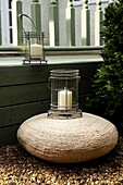 Rattan poof and lanterns beside a decked area of the garden