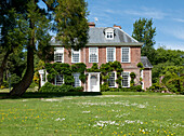 Lawned exterior of brick country house in Tiverton,  Devon,  England,  UK