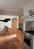 Offene Küche mit Holztisch und Stühlen und ausgeschnittener Walform in einem Haus in Ashford, Kent, England, UK