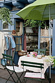 Table and chairs with green parasol at entrance to tea salon in Dordogne,  France