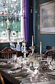 Lit candles and Christmas crackers on dining table of Tiverton farmhouse  Devon  UK