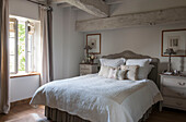 Handmade cushions on double bed at window in beamed Dordogne farmhouse  Perigueux  France