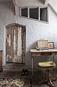Schreibtisch und Hocker an der Tür mit Schälschäden in einem Haus in Suffolk England UK