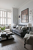 Closed shutters with sofa and artwork in living room of South London Victorian terraced house