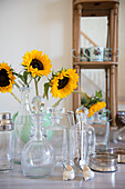 Sunflowers and glassware with silver spoons in 18th century Norfolk barn conversion  England  UK
