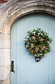 Christmas wreath on arched stone front door of Grade II Listed priory  Headcorn  Kent  UK