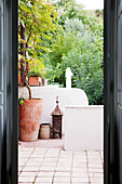 View through doorway to terracotta pot with lantern on terrace in Castro Marim, Portugal