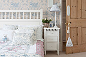 Cut tulips on bedside cabinet in light blue floral patterned bedroom of Brighton home East Sussex England UK