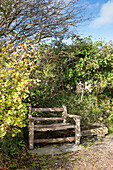 Hölzerne Parkbank im Garten eines Hauses in Devon England UK