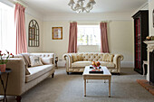 Cream sofas and vintage mirror in living room with pink curtains Petworth farmhouse West Sussex Kent
