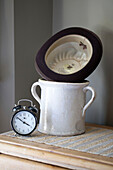 Bowler hat and vintage jar with alarm clock in Edwardian West Sussex townhouse England UK