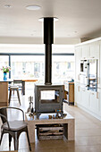 Freistehender, erhöhter Holzofen in der offenen Küche eines Hauses in West Wittering, West Sussex, England