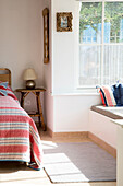 Fensterbank und Teppich mit gestreiften Bettdecken und Lampe in einem Haus in West Wittering, West Sussex, England