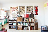 Gestapelte Kisten zur Aufbewahrung mit Kunstwerken im Wohnzimmer eines Hauses einer Londoner Familie, England, UK