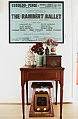 Vintage poster and wooden side table in hallway of London family home,  England,  UK