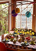 Daffodils on kitchen table with Easter decorations in London home   England   UK
