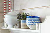 Blaue und weiße Keramikschalen mit Schnittblumen und Servierteller auf einem Regal in einer britischen Bauernhausküche