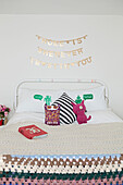 Neuartige Kissen auf dem Bett mit gehäkelter Decke in einem Londoner Haus, England, UK