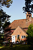 Outdoor furniture and brick facade of Brabourne farmhouse,  Kent,  UK