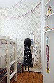 Bowler hat and dressing gown hang under bunting with bunk bed in boys room of Faversham home,  Kent,  UK