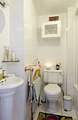 Badetücher hängen an einem Messingständer im weiß gefliesten Badezimmer eines Hauses in Faversham, Kent, UK