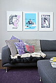 Gerahmte Drucke über Sofa mit Kissen im Wohnzimmer eines Londoner Stadthauses England UK