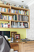 Hölzernes Bücherregal über Schreibtisch in Londoner Stadthaus England UK