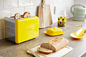 Aufgeschnittenes Brot im gelben Toaster mit Butterdose auf der Arbeitsplatte in der Küche von Alloa, Schottland UK