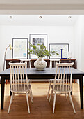 Blattarrangement auf Tisch mit weißen Esszimmerstühlen in einem Londoner Haus UK