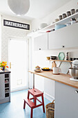 Red kitchen steps with pale wood counter in Sheffield home  Yorkshire  UK