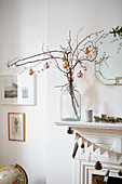 Weihnachtskugeln und Zweige auf dem Kaminsims in einem Londoner Haus UK