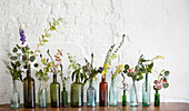Verschiedene Blumen in alten Flaschen in einem Londoner Atelier UK