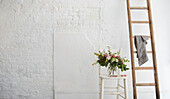 Schnittblumen und Leiter in einem getünchten Londoner Atelier UK