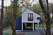 Lit facade of modern new build in Devon woodland  UK