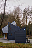 Grey woodclad facade of new build in Devon woodland  UK