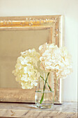 Detail of frame on marble mantel with white hydrangea flowers