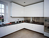 Modern white fitted kitchen with marble worktop