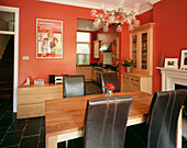 Dining room with bright red walls with adjoining kitchen 