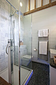 Glass shower cubicle in grey tiled wet room in watermill conversion